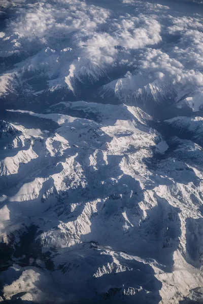 Snowy mountains and clouds aerial view