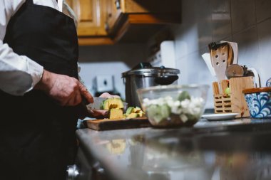 59 yaşındaki evinin mutfağında çalışan adam.