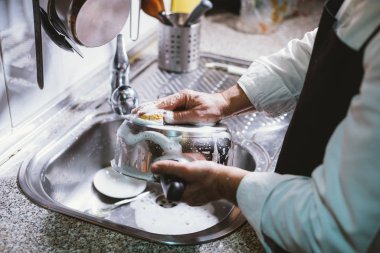 59 yaşındaki adam evinin mutfağında muz yemek.