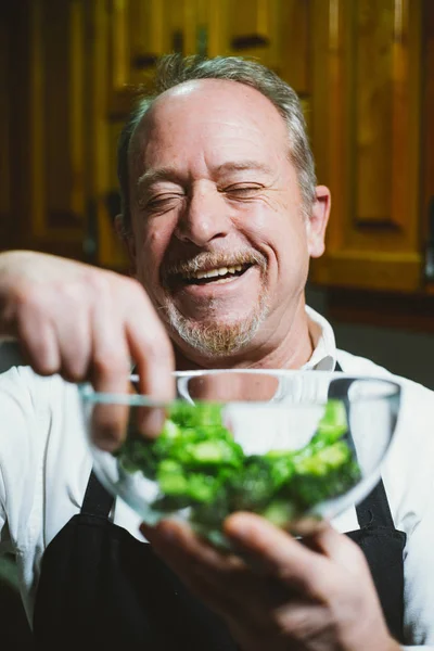 Retrato hombre de 59 años mostrando tazón con verduras en el — Foto de Stock