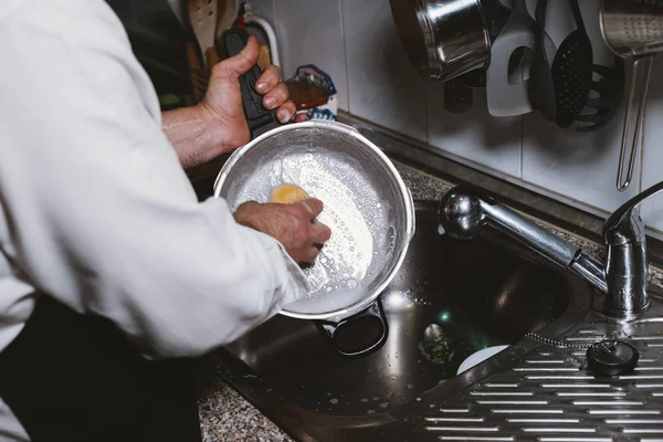 L'uomo di 59 anni mangia banana nella cucina di casa sua . — Foto Stock