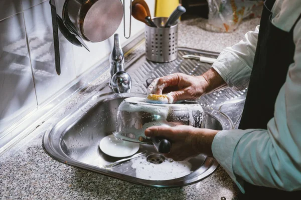 Hombre de 59 años come plátano en la cocina de su casa . — Foto de Stock