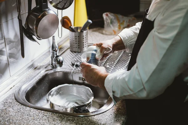 Hombre de 59 años come plátano en la cocina de su casa . — Foto de Stock