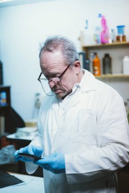  59 yaşındaki adam akıllı telefon ve lateks eldiven ile