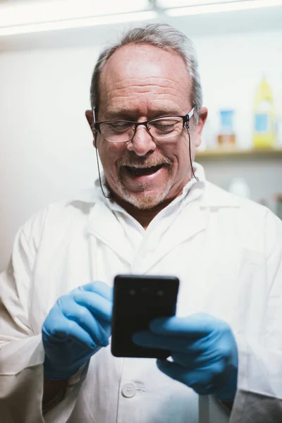 59  year  old man with smartphone and latex gloves