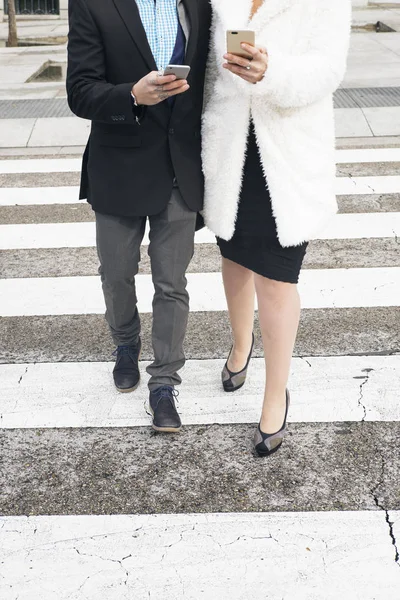 Erkek ve kadın smartphone zebra kavaşağında yürüyüş — Stok fotoğraf