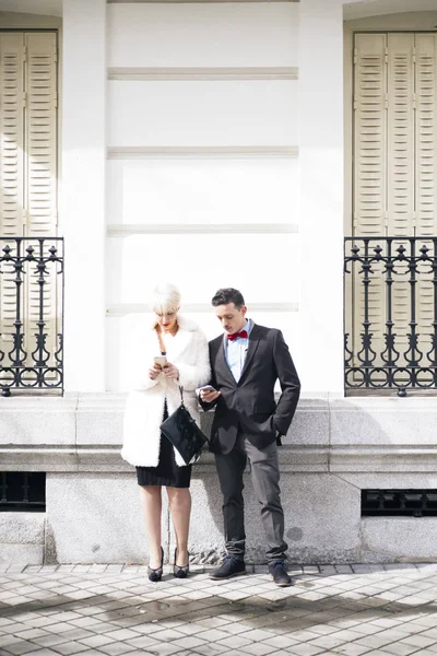 Мужчина и женщина с зонтичным текстом на смартфоне — стоковое фото