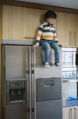 Çocuk buzdolabının oturuyor