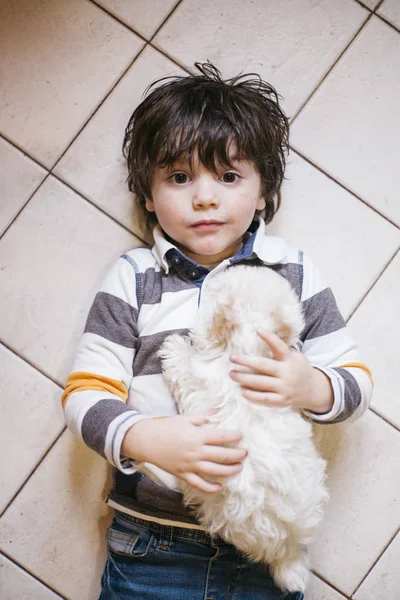 Kleine jongen liggend met witte hond — Stockfoto