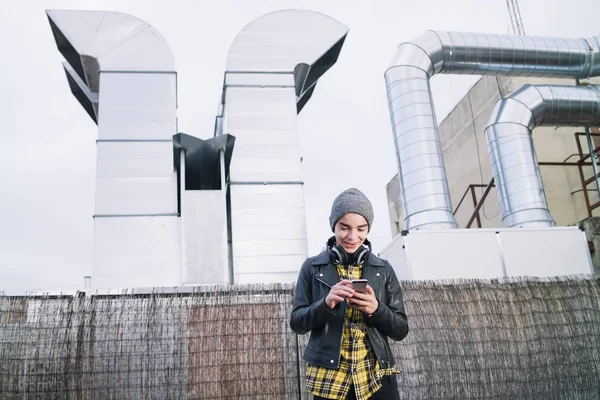 Menino com smartphone e fones de ouvido na rua — Fotografia de Stock