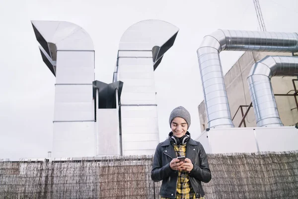 Niño con smartphone y auriculares en la calle — Foto de Stock