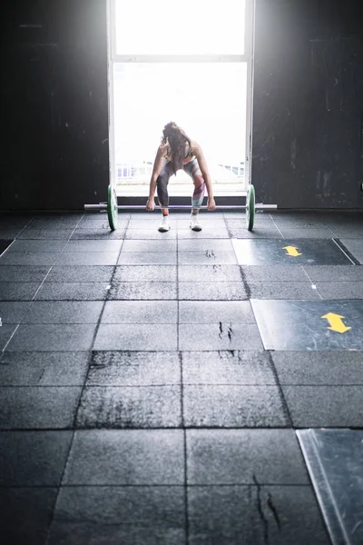 Визначена спортсменка, що піднімає важкий штангу — стокове фото