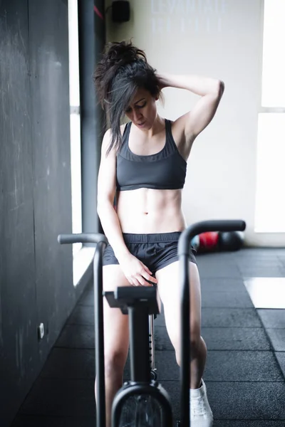 Mujer concentrada haciendo ejercicio en el gimnasio — Foto de Stock