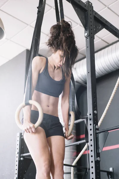 Mulher treinando com anéis — Fotografia de Stock