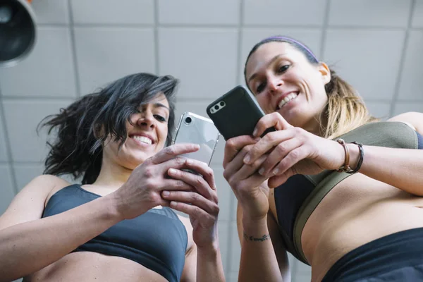 Dvě ženy s telefonem v tělocvičně — Stock fotografie
