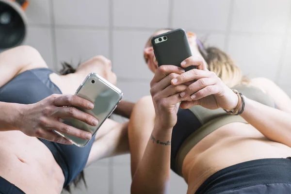 Due donne con telefono in palestra — Foto Stock