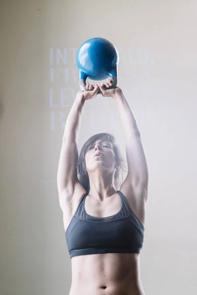 Mujer joven entrenando con mancuerna — Foto de Stock