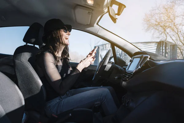 Krásná mladá žena pomocí svého mobilního telefonu v autě — Stock fotografie