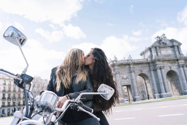 Due donne che si baciano montate sulla moto nella città di Madrid — Foto Stock