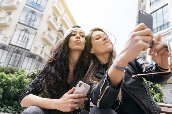 Duas mulheres com smartphone na rua — Fotografia de Stock