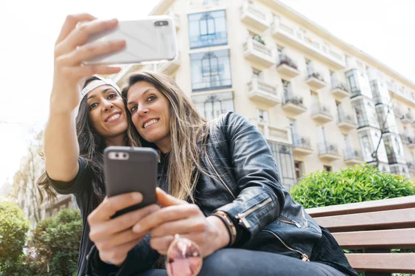 Duas mulheres com smartphone na rua — Fotografia de Stock