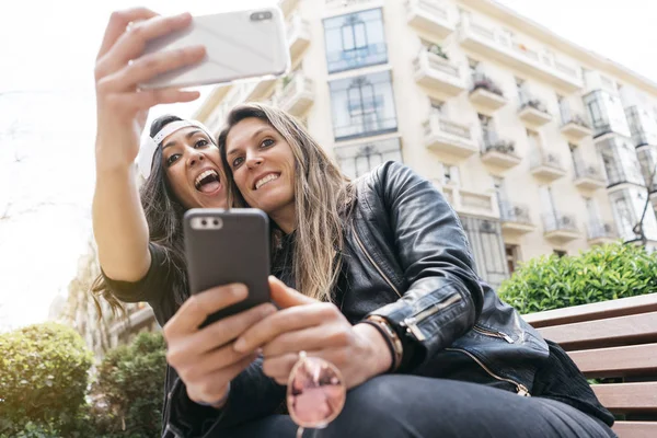 Duas mulheres com smartphone na rua — Fotografia de Stock