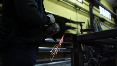 Adam öğütücüyle çalışıp metal kesiyor..