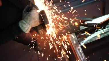 Adam öğütücüyle çalışıp metal kesiyor..