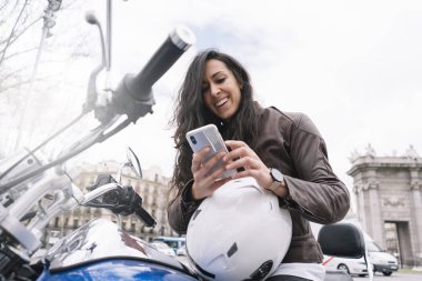 Bir motosiklet smartphone kullanarak şehirde kadınla