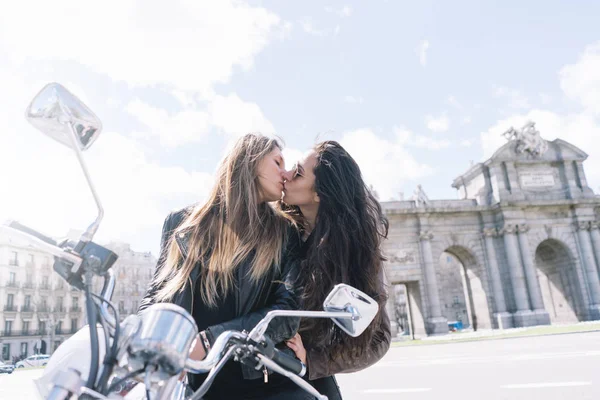 Duas mulheres beijando montado na moto na cidade de Madrid — Fotografia de Stock