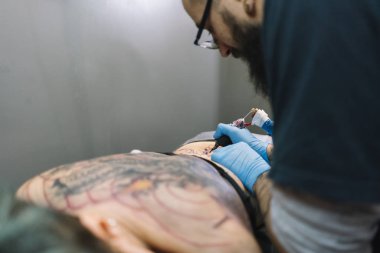 Usta bir kadına dövme yaptırıyor.