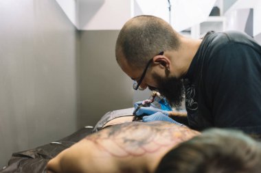 Usta bir kadına dövme yaptırıyor.