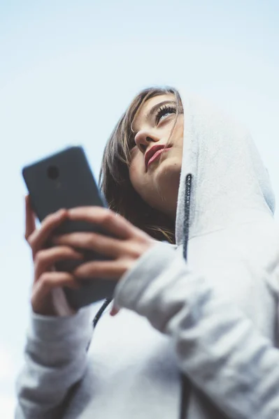 Портрет дівчини-підлітка зі спортивним одягом та смартфоном — стокове фото
