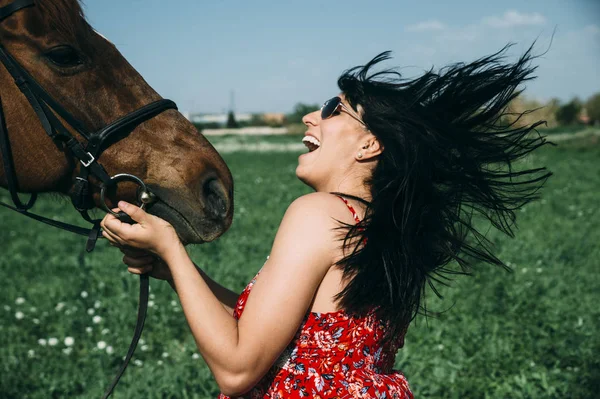 Gravid kvinna med häst i det gröna fältet — Stockfoto