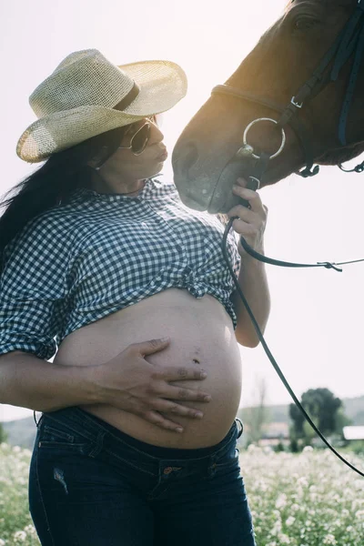 Mulher grávida com cavalo no campo verde — Fotografia de Stock