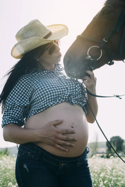Donna incinta con cavallo nel campo verde — Foto Stock
