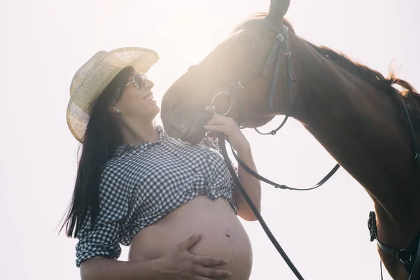 Mulher grávida com cavalo no campo verde — Fotografia de Stock