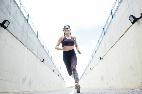 Uma bela mulher a correr na estrada. Fitness, treino, esporte, conceito de estilo de vida . — Fotografia de Stock