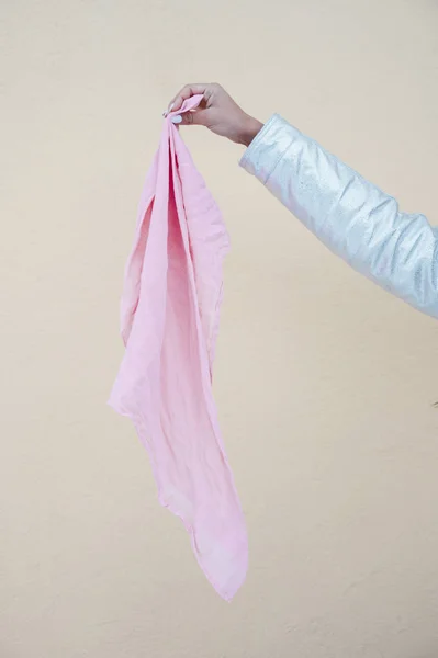 Una mano de mujer sosteniendo la bufanda rosa. Concepto vencer al cáncer — Foto de Stock