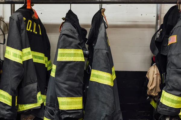 Uniformes de bomberos dentro de una estación de bomberos —  Fotos de Stock