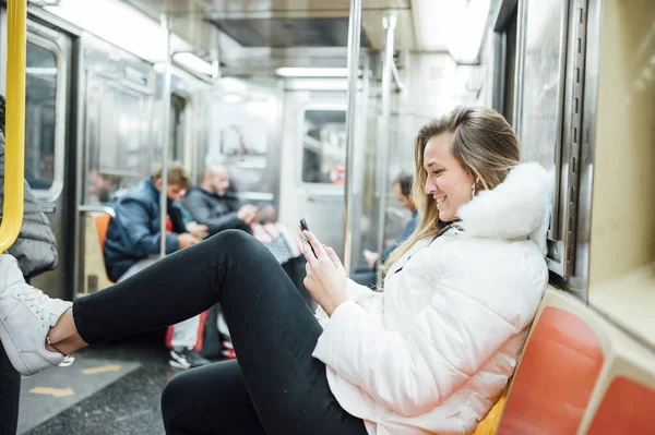 Nainen matkustaa metrossa älypuhelimen kanssa — kuvapankkivalokuva