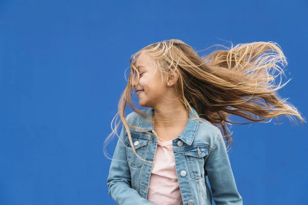 Liten flicka med blont hår snurrar utanför — Stockfoto