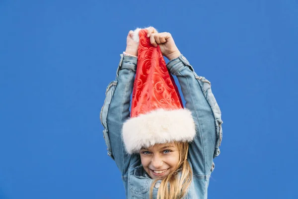 Menina loira dançando com um chapéu de Papai Noel. Feliz Natal! ! — Fotografia de Stock