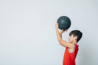 Boy playing basketball on studio clipart