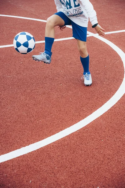 Маленький невпізнаваний хлопчик грає у футбол — стокове фото