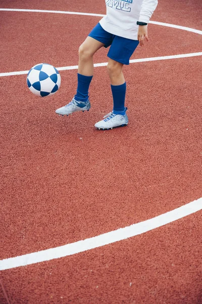 Маленький невпізнаваний хлопчик грає у футбол — стокове фото