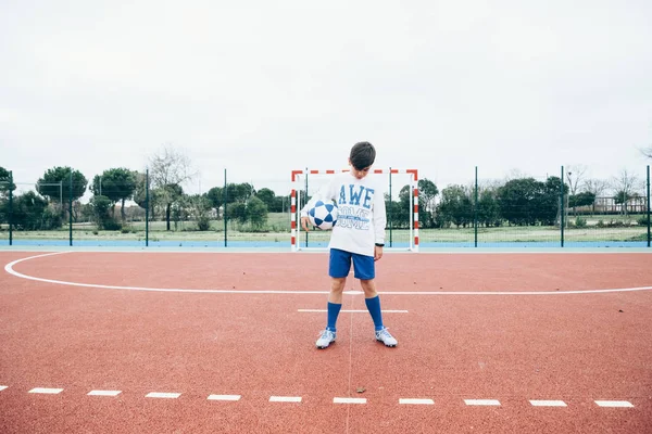 Giocatore di calcio ragazzo tenendo la palla a mano — Foto Stock