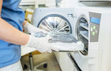 Dişçi aletleri sterilize ediyor.