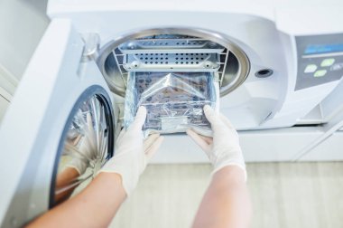 Dişçi aletleri sterilize ediyor.