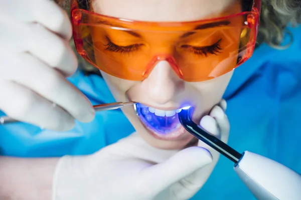 Dentista examinando a un paciente con luz UV —  Fotos de Stock